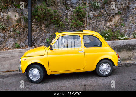 Yellow Fiat 500 Cinquecento parked in a street on the Amalfi Coast, Campania, Mediterranean, Italy Stock Photo
