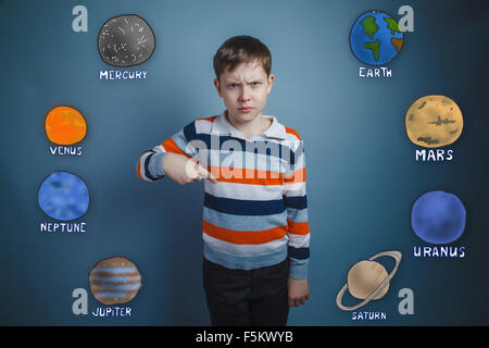 Teen boy frowned dissatisfied points a finger down the planets o Stock Photo