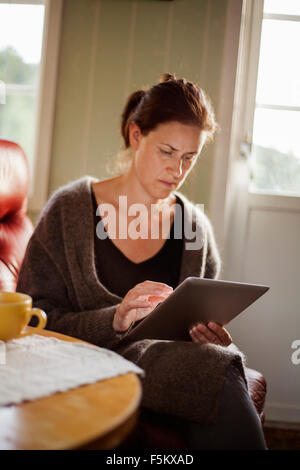 Mid-adult woman using digital tablet