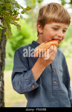 Sweden, Uppland, Runmaro, Barrskar, Portrait of boy (4-5) eating hot dog