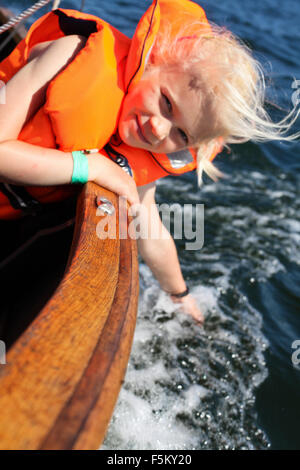 Sweden, Uppland, Runmaro, Barrskar, Girl (6-7) in sailboat