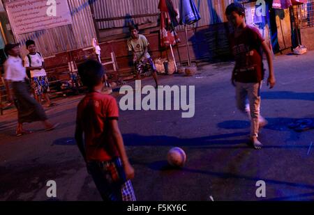 Yangon, Myanmar. 6th November, 2015.  Teenagers play football on the streets of central Yangon. Photo taken 5 Nov 2015.  Myanmar citizens hope that a new government will usher in democracy and economic prosperity. Analysts predict a landslide victory for Aung San Suu Kyi's National League for Democracy party during the election this Sunday. Credit:  Arthur Jones Dionio/Alamy Live News Stock Photo