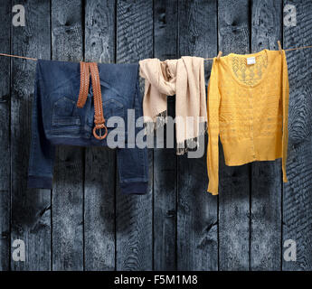 Women's clothing on a clothesline on wood background Stock Photo