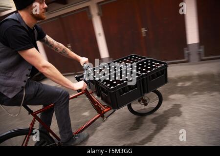 Man delivering beer on bicycle, Munich, Bavaria, Germany Stock Photo