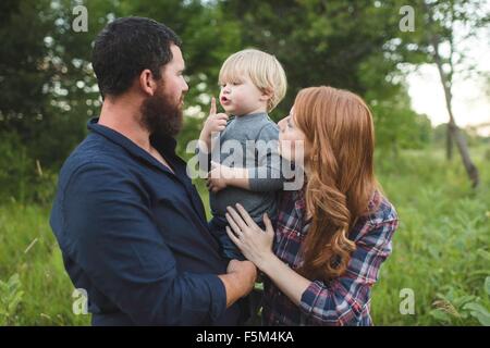 Mother and father holding young son, outdoors Stock Photo