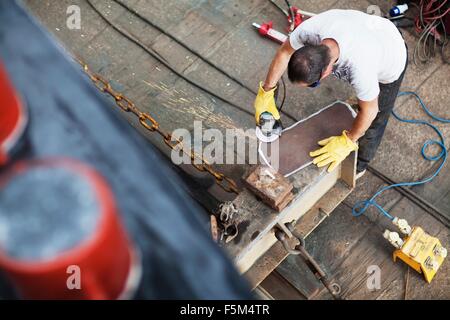 High angle view of worker preparing steel in shipyard workshop Stock Photo
