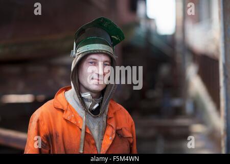 Portrait of welder wearing welding mask in shipyard workshop