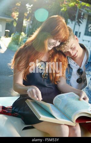 Young couple in vintage convertible reading road atlas Stock Photo
