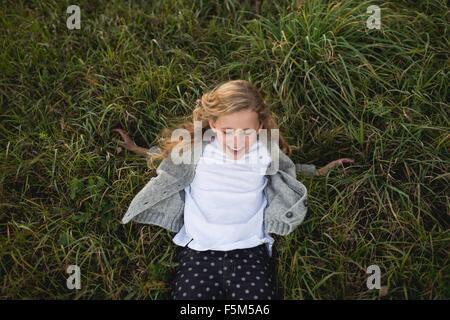 Young girl playing on grass, overhead view Stock Photo