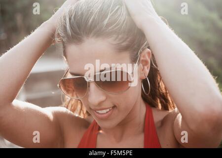 Young woman with hands in hair at coast Stock Photo