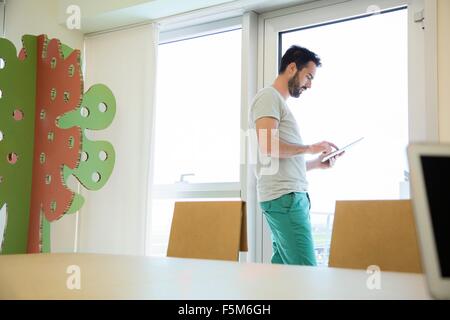 Young male designer using digital tablet touchscreen in office Stock Photo