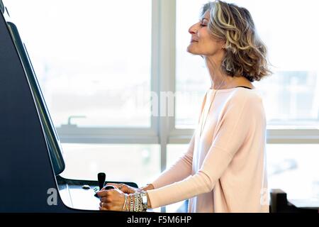 Senior female designer playing on games machine in office Stock Photo