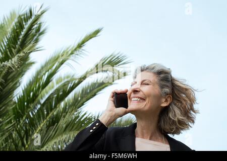Senior woman chatting on smartphone Stock Photo