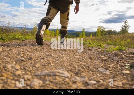 Mid adult man walking on dirt path, low section Stock Photo