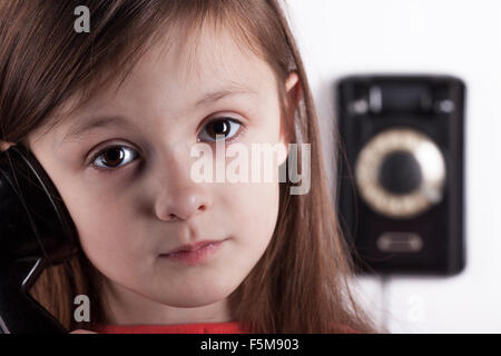 Serious sad child talking on phone, white background Stock Photo