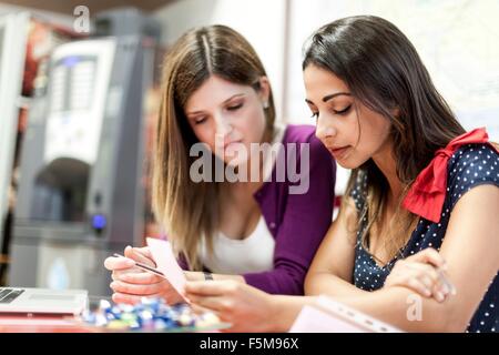 Two young women sitting together, studying Stock Photo