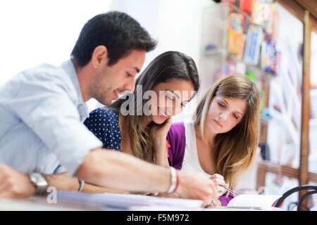 Three friends sitting together, studying Stock Photo
