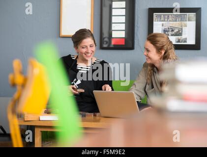 Female printer and designer using laptop in workshop office Stock Photo
