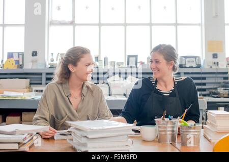 Female print designers talking in workshop Stock Photo