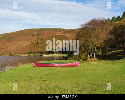 Red Canoe Llyn Geirionydd Conwy North Wales on lovely autumn day where northern edge of  Gwydyr Forest meets lower slopes of Carneddau mountains Stock Photo