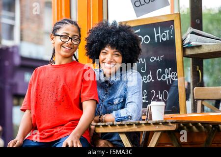 Portrait of boy sitting on mothers lap at sidewalk cafe Stock Photo