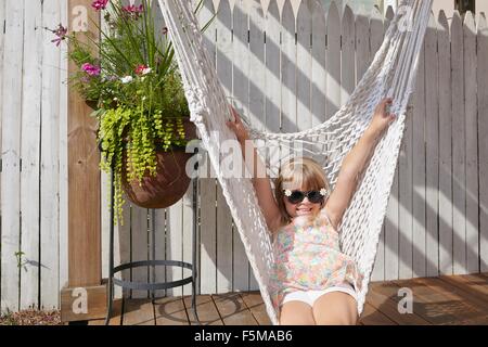 Girl lying in hammock on porch Stock Photo