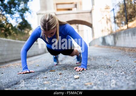Woman doing push ups on bridge, Arroyo Seco Park, Pasadena, California, USA Stock Photo