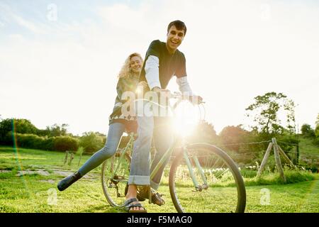 Portrait of young couple on bicycle Stock Photo