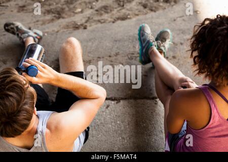 Overhead view of joggers taking break on kerb Stock Photo