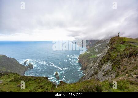 Daughter sitting on fathers shoulders looking at view from cliff, Slieve League, County Donegal, Ireland Stock Photo