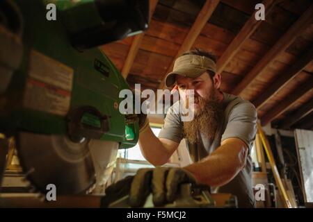 Wood artist using machinery in workshop Stock Photo