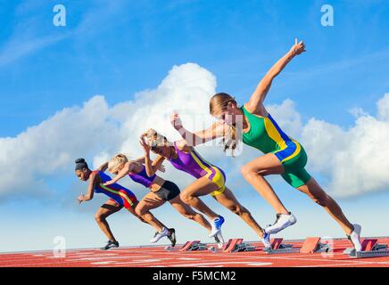 Four female athletes on athletics track, starting race Stock Photo