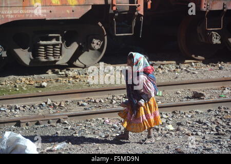 Little girl carrying her brother / sister beside the train road at Sierra Tarahumara, Chihuahua, Mexico Stock Photo