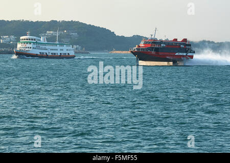 TurboJET Jetfoil (Hydrofoil) En-Route From Macau To Hong Kong, Passing A Standard Ferry From Cheung Chau Island. Stock Photo