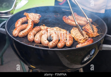 Barbecue with delicious grilled sausages on grill Stock Photo