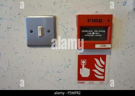 A Fire Alarm and light switch in an office building Stock Photo