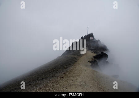 The cross at Shrine of the Virgin of Guagua Pichincha in a rare moment of clearing fog. Stock Photo