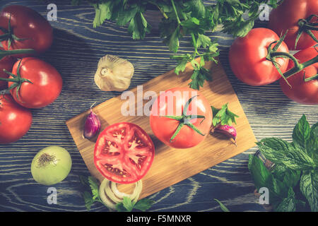 Fresh tomato and vegetables arranged on a wooden table Stock Photo