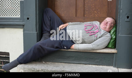 drunk on street,  drunk in doorway,  sleeping on the streets homlessness Stock Photo