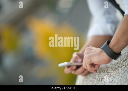 Man using a cell phone in a park. close-up hands Stock Photo