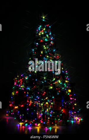 Decorated Christmas tree lit up with colorful lights at night Stock Photo