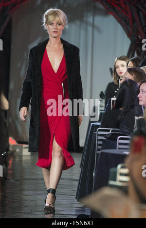 Calgary, Alberta, Canada. 7th Nov, 2015. A female model walks the Catwalk at HOLT RENFREW's Fashion Gala in Calgary wearing a red dress by DONNA KARAN and a black over jacket by MSGM. Credit:  Baden Roth/ZUMA Wire/Alamy Live News Stock Photo