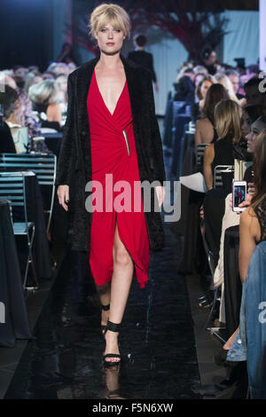 Calgary, Alberta, Canada. 7th Nov, 2015. A female model walks the Catwalk at HOLT RENFREW's Fashion Gala in Calgary wearing a red dress by DONNA KARAN and a black over jacket by MSGM. Credit:  Baden Roth/ZUMA Wire/Alamy Live News Stock Photo