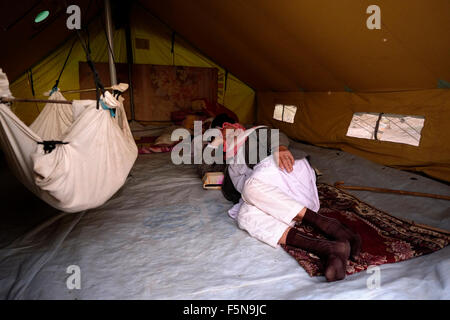 An elderly Yazidi man laying inside a temporary tent shelter at a refugee camp for displaced people from the minority Yazidi sect which were driven from their homes in Sinjar by Islamic State militants in the city of Zakho Northern Iraq. Stock Photo