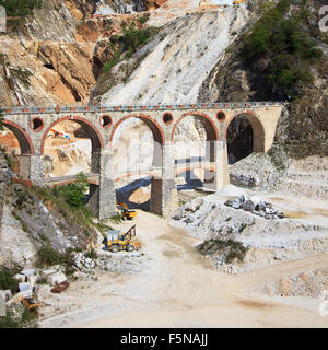 White marble quarry old bridge and excavators at work. Apuan Alps, Carrara, Tuscany, Italy, Europe Stock Photo