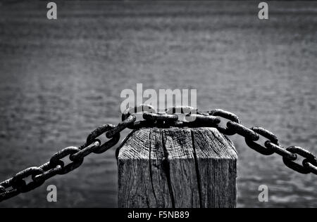 Chain link fence barrier by waterside Stock Photo