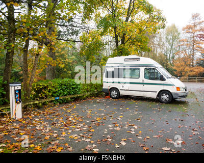 Camper van connected to hook-up on a campsite in autumn UK Stock Photo