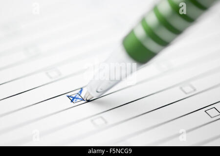 oblique close-up of a green pen on a sheet of paper with lines crossing in a box Stock Photo