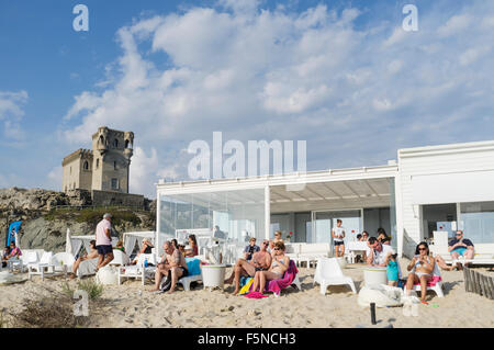 People at an alfresco beach bar with Santa Catalina castle in background. Tarifa, Cadiz province, Andalusia, Spain Stock Photo