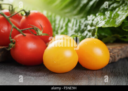 red and yellow cherry tomatoes with salad leaves Stock Photo